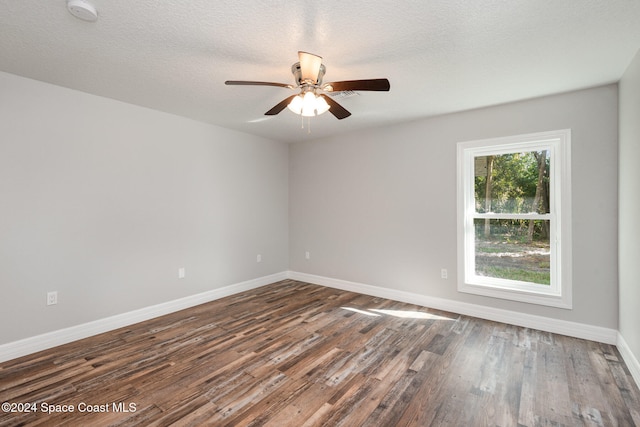 spare room with a textured ceiling, dark hardwood / wood-style flooring, and ceiling fan