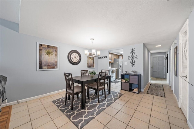 dining space with light tile patterned floors, a chandelier, and a textured ceiling