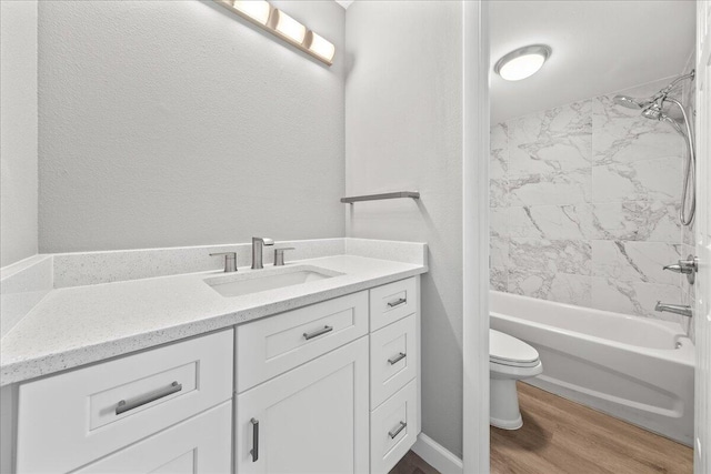 full bathroom featuring tiled shower / bath combo, wood-type flooring, vanity, and toilet