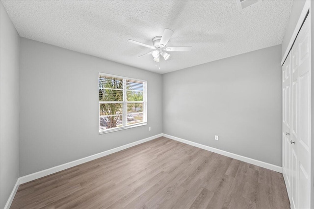 unfurnished bedroom featuring a closet, hardwood / wood-style floors, and ceiling fan