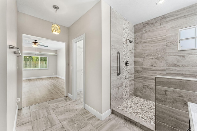 bathroom featuring hardwood / wood-style floors, ceiling fan, and a tile shower