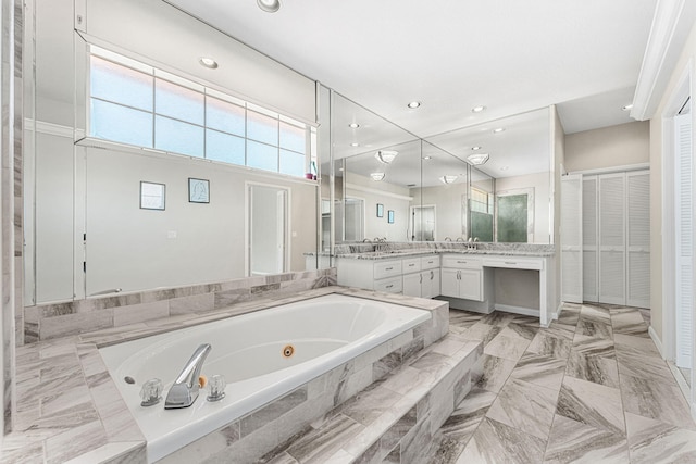 bathroom with vanity and a relaxing tiled tub