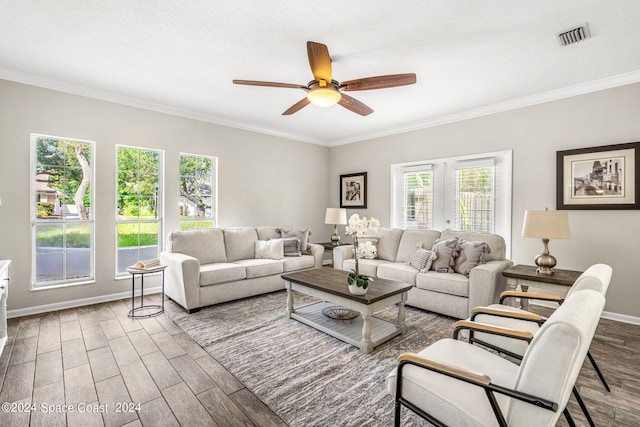 living room featuring ceiling fan, ornamental molding, a healthy amount of sunlight, and wood-type flooring