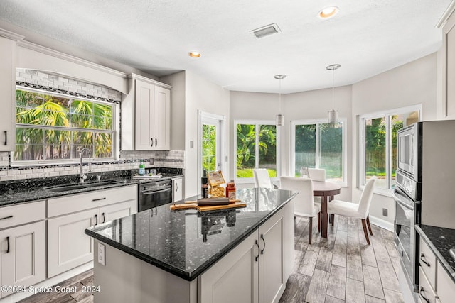 kitchen featuring white cabinetry, sink, a center island, and stainless steel appliances