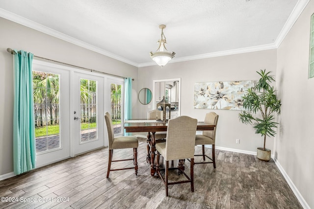 dining room featuring a textured ceiling, crown molding, dark hardwood / wood-style flooring, and french doors