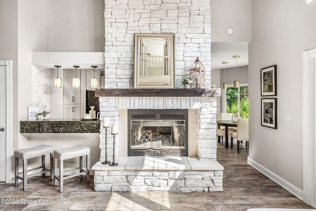 interior space with wood-type flooring and a stone fireplace