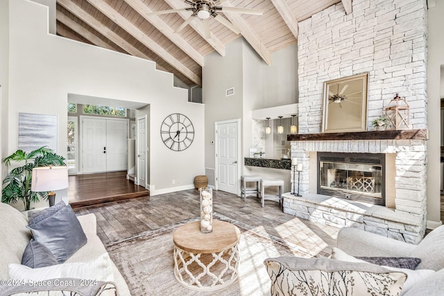 living room featuring wooden ceiling, high vaulted ceiling, hardwood / wood-style flooring, a fireplace, and beam ceiling