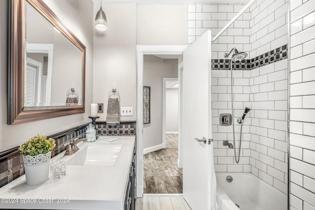 bathroom featuring hardwood / wood-style floors, vanity, and tiled shower / bath