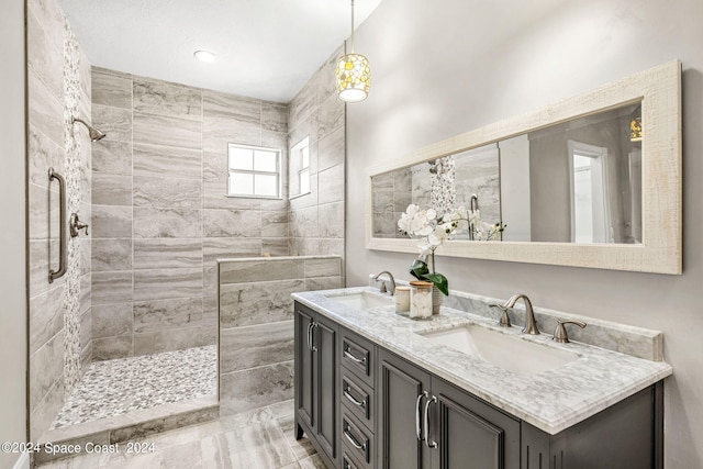 bathroom featuring a tile shower, tile patterned floors, and vanity