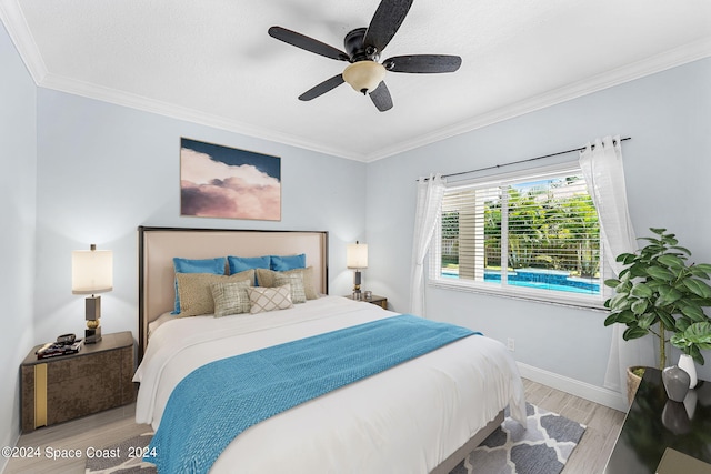 bedroom featuring ceiling fan, ornamental molding, and light wood-type flooring