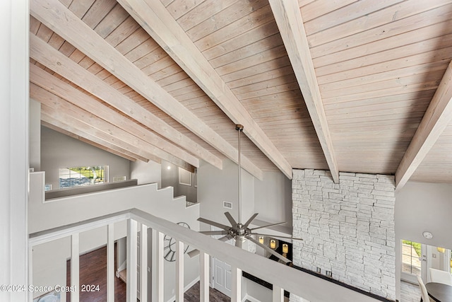 corridor with hardwood / wood-style floors, lofted ceiling with beams, wooden ceiling, and a wealth of natural light