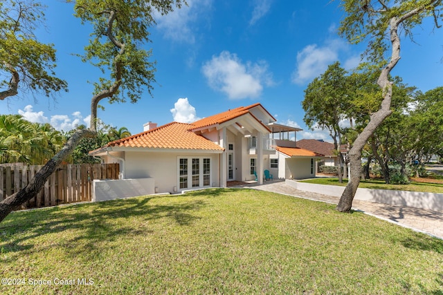 back of property featuring a yard and french doors