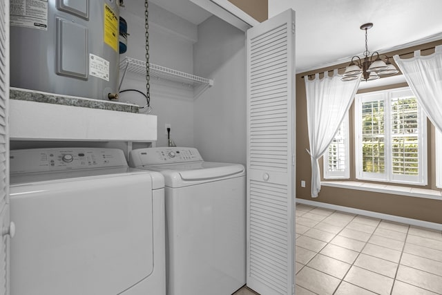 laundry room featuring washing machine and clothes dryer, light tile patterned flooring, electric water heater, a chandelier, and laundry area