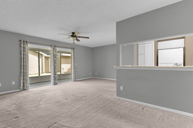 empty room featuring light colored carpet, a textured ceiling, and ceiling fan