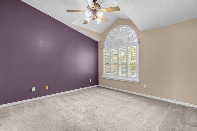 carpeted spare room with a textured ceiling, ceiling fan, and vaulted ceiling