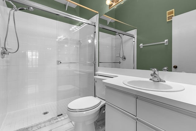 bathroom featuring a shower with door, toilet, tile floors, and large vanity