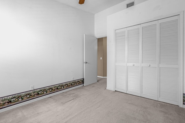 unfurnished bedroom featuring a closet, carpet, visible vents, and a ceiling fan