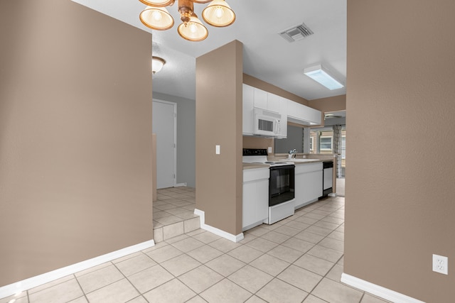 kitchen featuring dishwashing machine, white microwave, electric range, visible vents, and light countertops