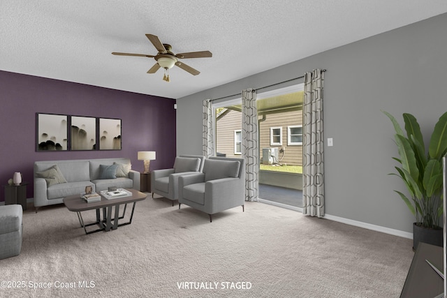 living area with a ceiling fan, carpet, a textured ceiling, and baseboards