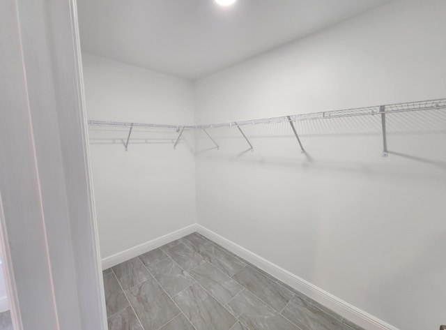 walk in closet with tile flooring