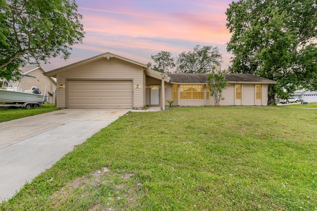 ranch-style house featuring a garage and a yard