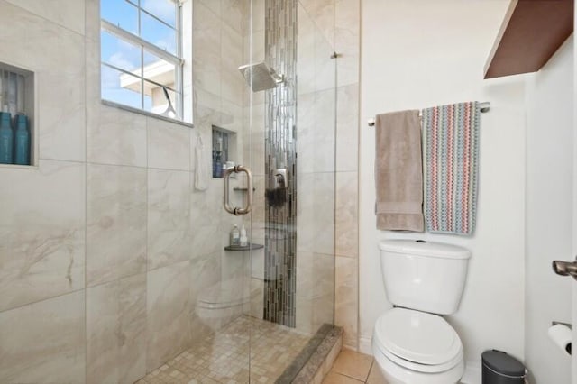 bathroom with a shower with door, toilet, and tile floors