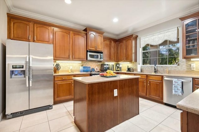 kitchen with appliances with stainless steel finishes, a kitchen island, backsplash, and light tile floors