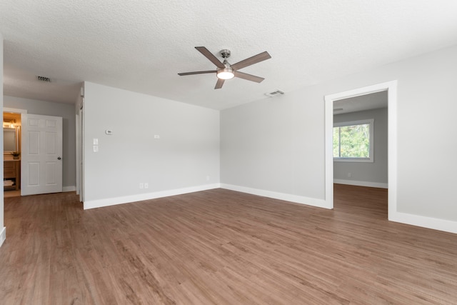 spare room with wood-type flooring, ceiling fan, and a textured ceiling