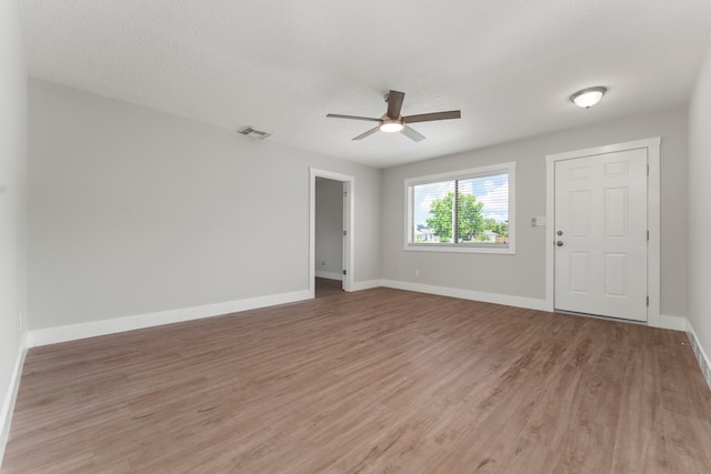 unfurnished room featuring a textured ceiling, hardwood / wood-style floors, and ceiling fan