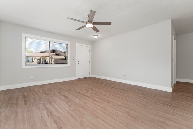 spare room featuring light hardwood / wood-style floors, ceiling fan, and a textured ceiling