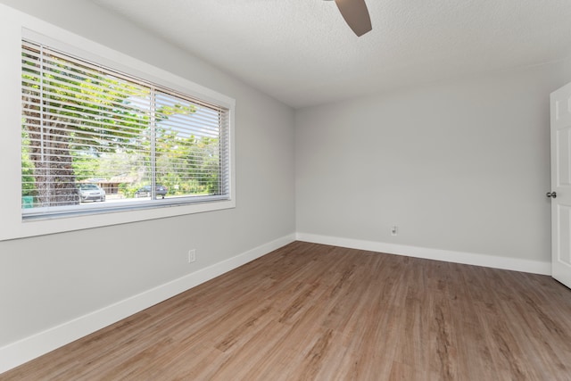 unfurnished room with a textured ceiling, ceiling fan, and hardwood / wood-style flooring