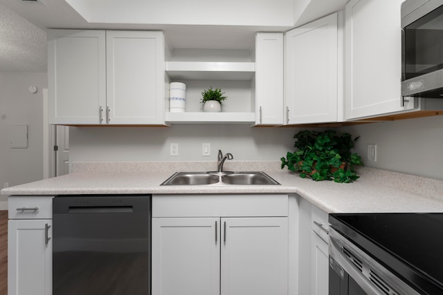 kitchen with appliances with stainless steel finishes, sink, hardwood / wood-style flooring, and white cabinets