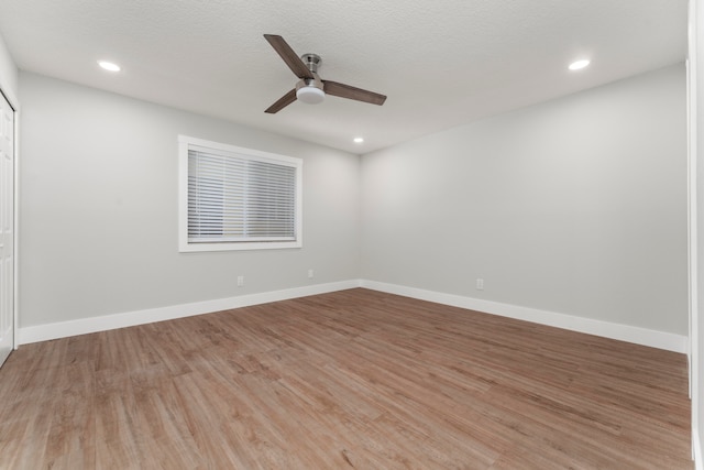 empty room with a textured ceiling, ceiling fan, and light wood-type flooring