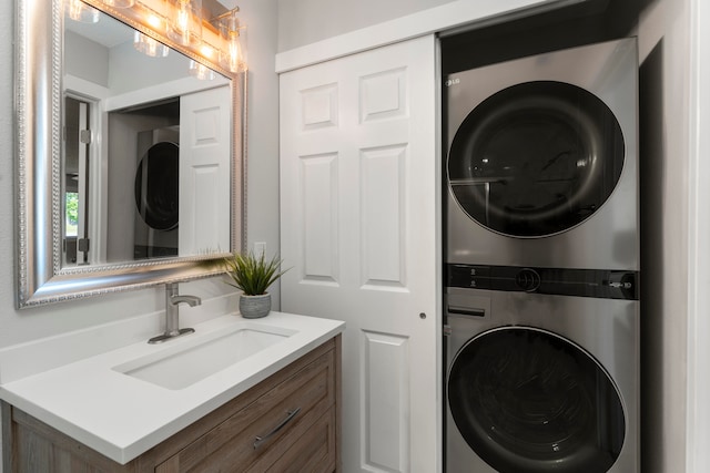 clothes washing area featuring stacked washing maching and dryer and sink