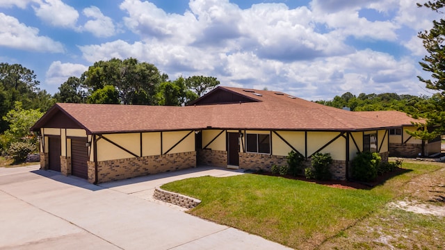 tudor house featuring a front lawn and a garage