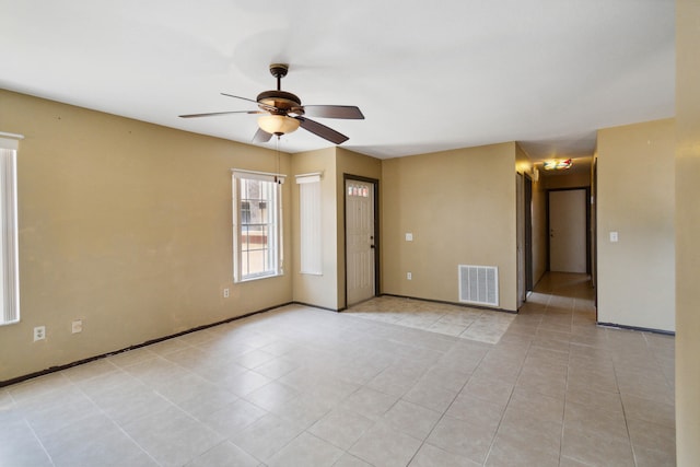 tiled spare room featuring ceiling fan