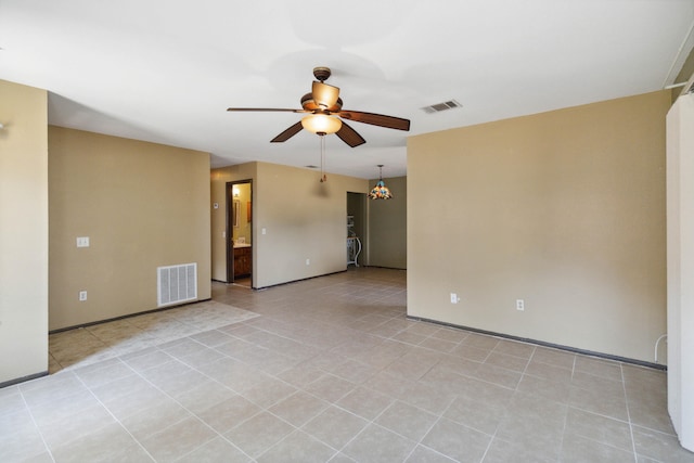 tiled spare room with ceiling fan