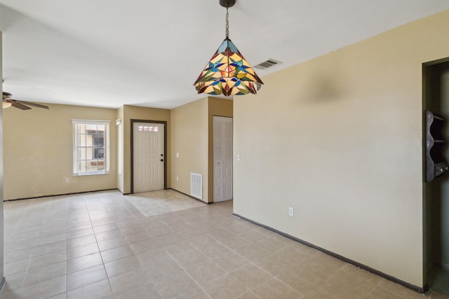 unfurnished room with ceiling fan and light tile floors