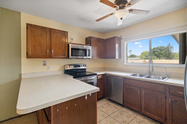 kitchen featuring stainless steel appliances, dark brown cabinetry, sink, ceiling fan, and light tile floors