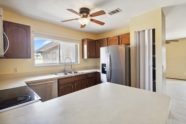 kitchen featuring dark brown cabinetry, stainless steel appliances, ceiling fan, sink, and light tile floors