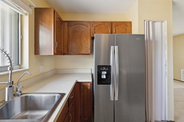 kitchen with sink, stainless steel fridge with ice dispenser, and light tile floors