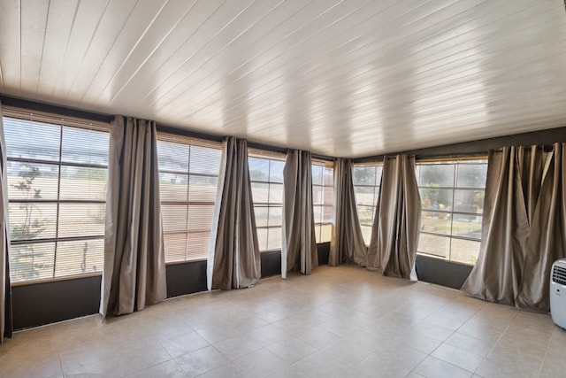 unfurnished sunroom featuring a healthy amount of sunlight and wood ceiling