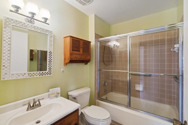 full bathroom with a chandelier, bath / shower combo with glass door, vanity, and toilet