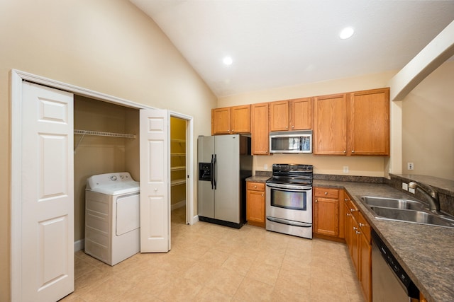 kitchen featuring high vaulted ceiling, appliances with stainless steel finishes, washer / dryer, sink, and light tile floors