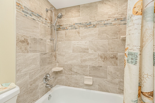 bathroom featuring tiled shower / bath and toilet