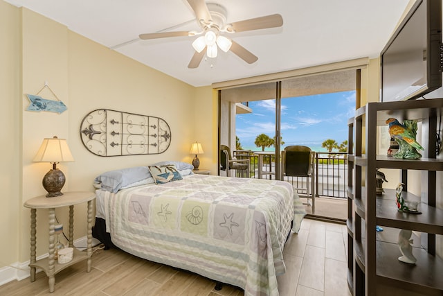 bedroom with a wall of windows, ceiling fan, light hardwood / wood-style floors, and access to outside