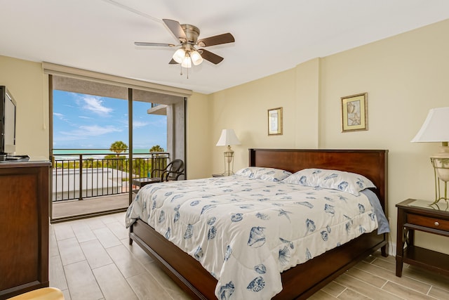 bedroom with a water view, ceiling fan, and access to exterior