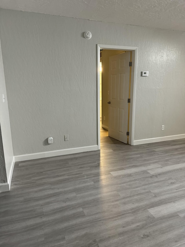 spare room with wood-type flooring and a textured ceiling