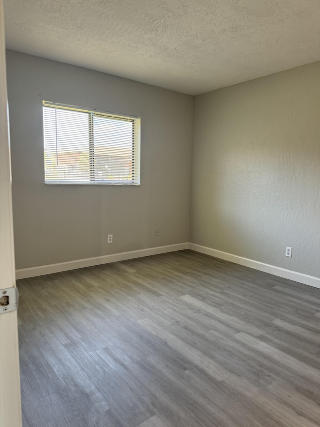 unfurnished room featuring wood-type flooring, plenty of natural light, and a textured ceiling