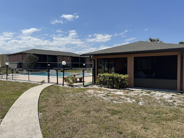 exterior space with a front lawn and a fenced in pool